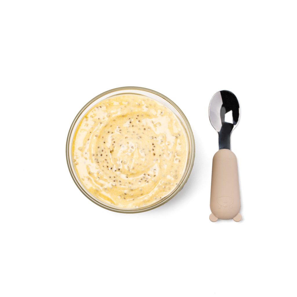 Yogurt with chia seeds served in a baby bowl on a white background