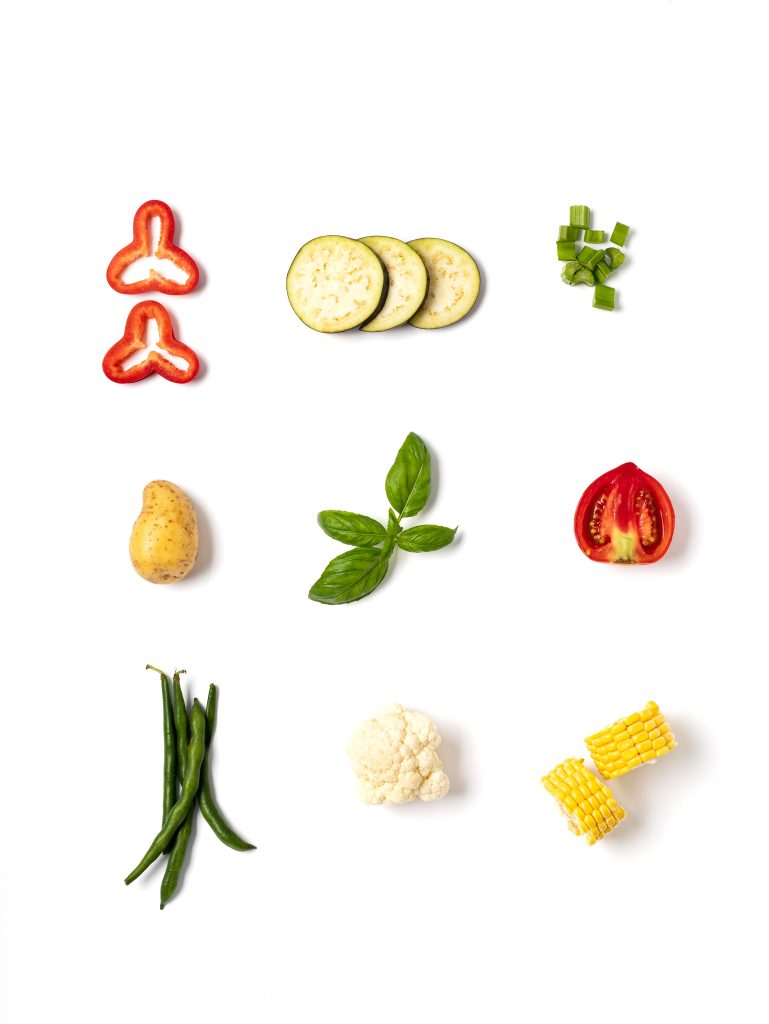 Minimalist composition of fresh vegetables, arranged as separate elements in rows of three on a white background, top view